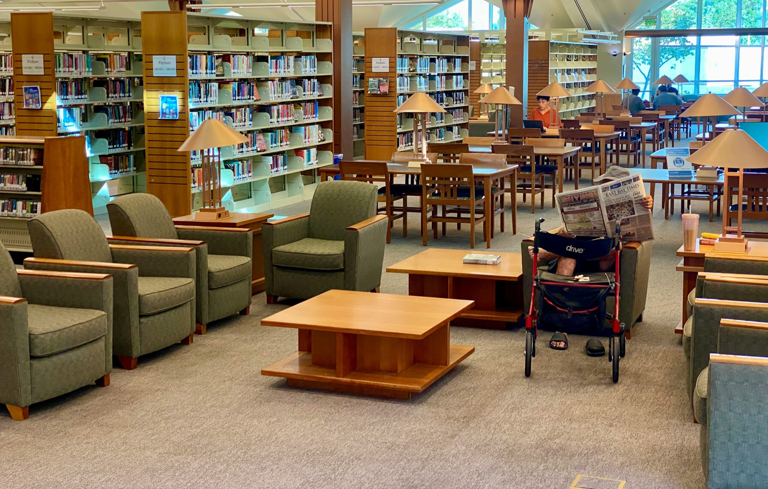 Public library interior with tall bookshelves and reading area